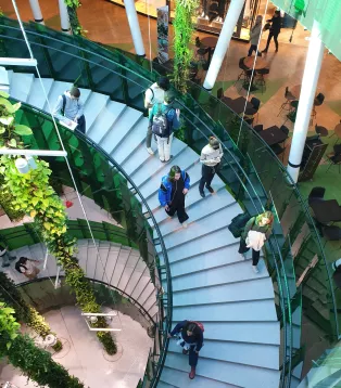 En bild tagen ovanifrån på en trappa inuti köpcentrat Emporia med personer som går i trappan.
